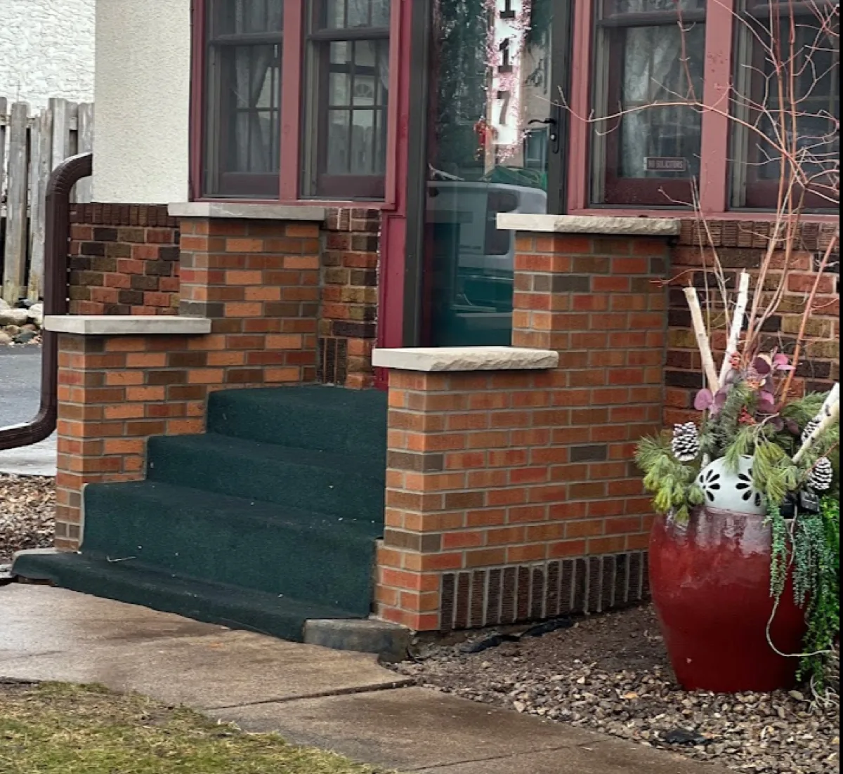 Brick porch piers and front steps with stone caps on a classic home