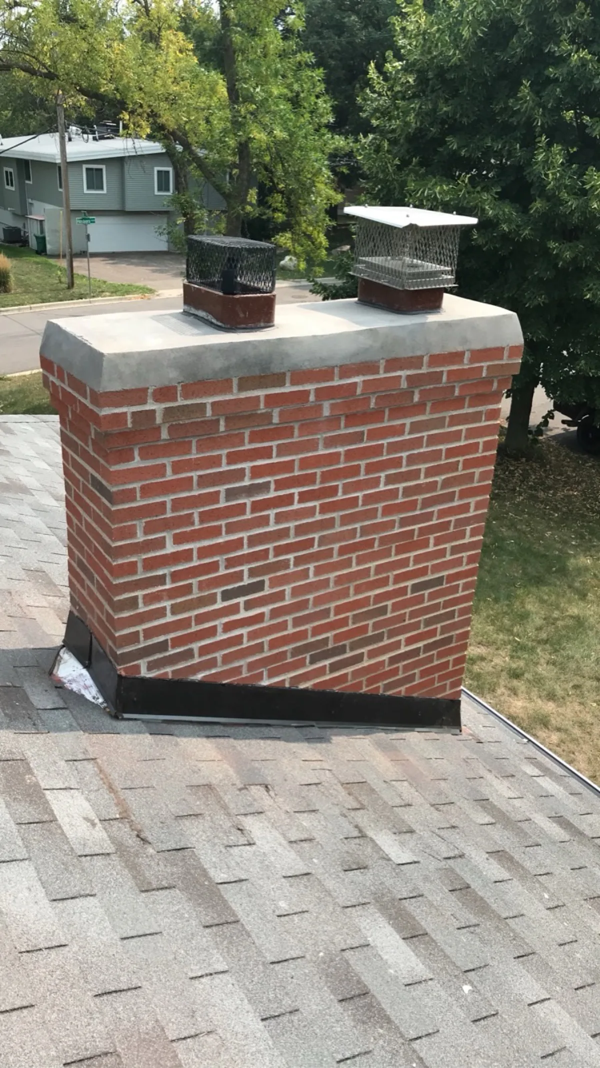 Rebuilt red brick chimney with new concrete crown and stainless caps