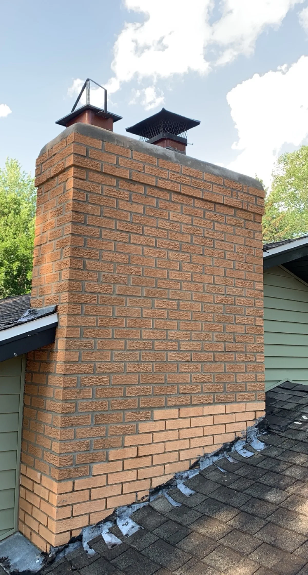 Tan brick chimney rebuilt with new concrete crown
