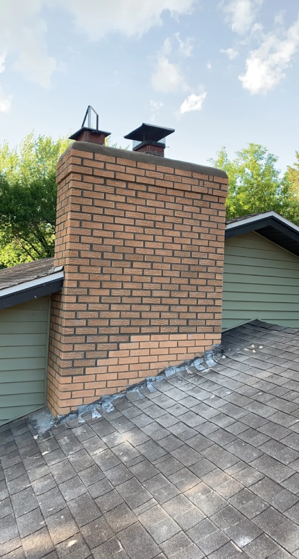 Second angle of a tan brick chimney rebuild above the roofline
