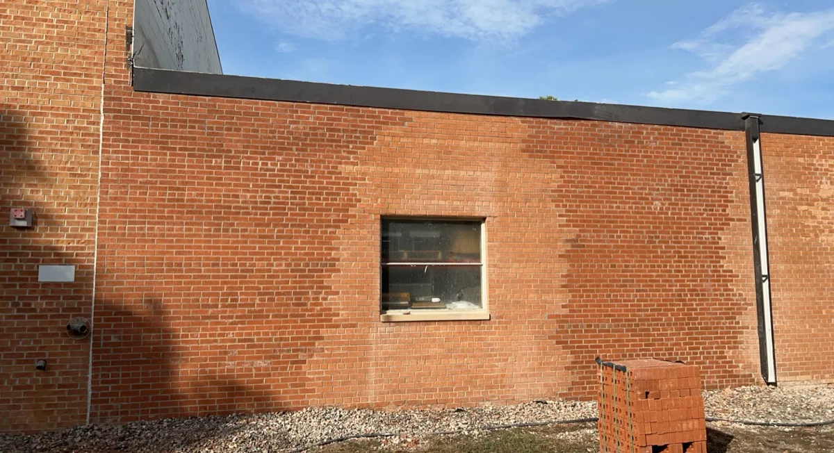 Repaired commercial brick wall with fresh pallet of brick staged