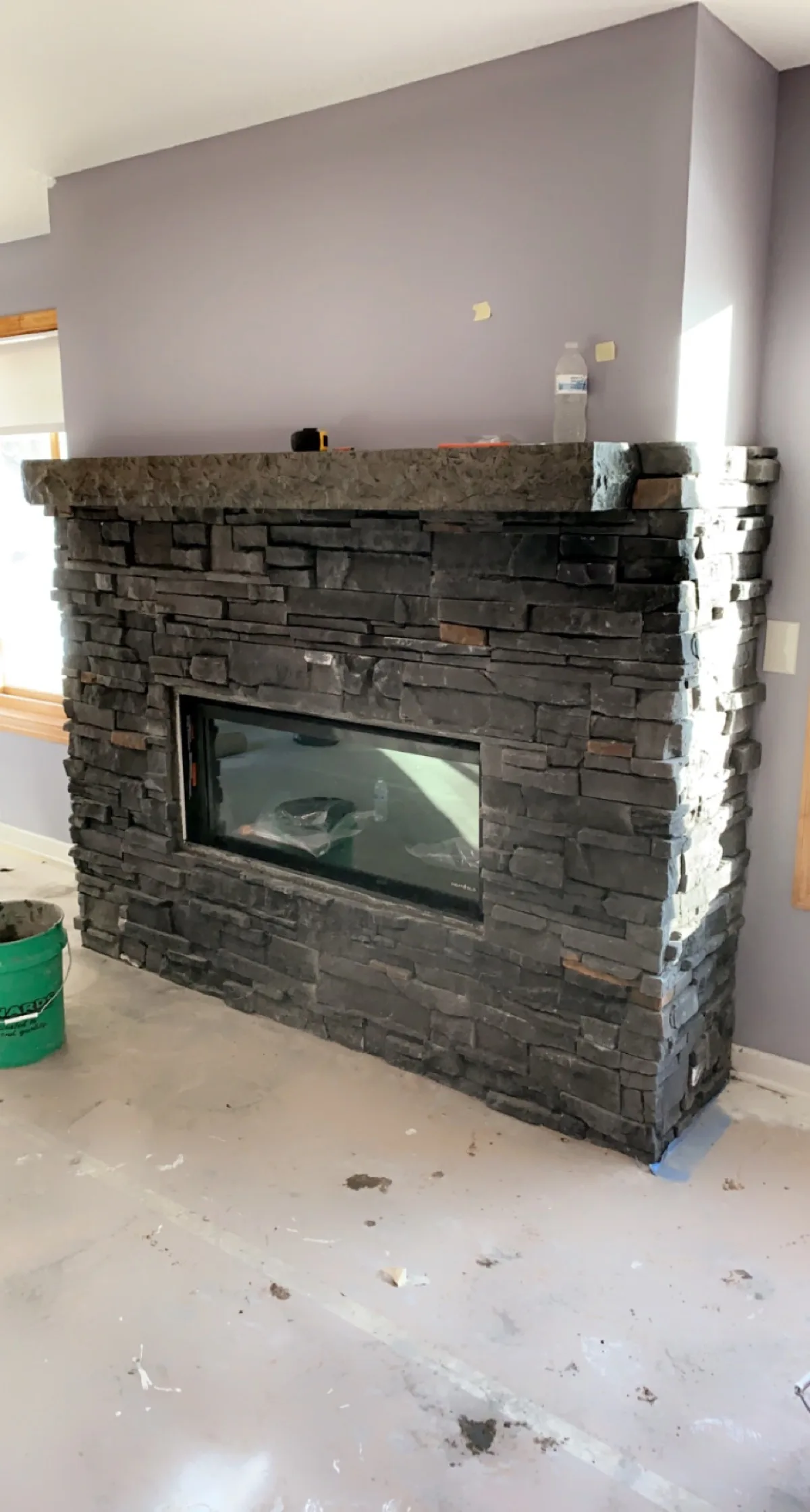 Stacked stone fireplace surround with linear insert, mid-install