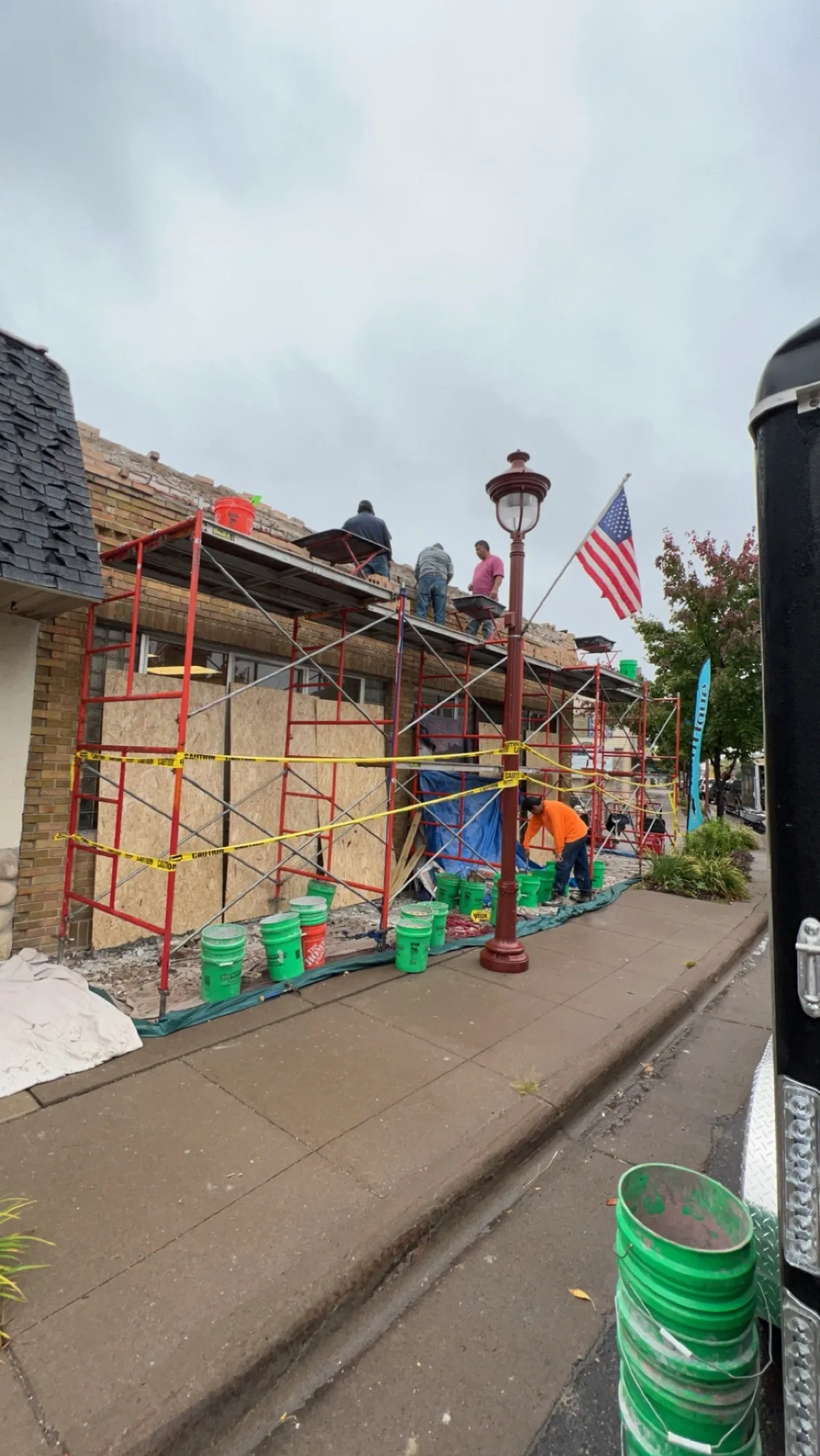 Metro Masonry crew rebuilding a storefront parapet from scaffolding